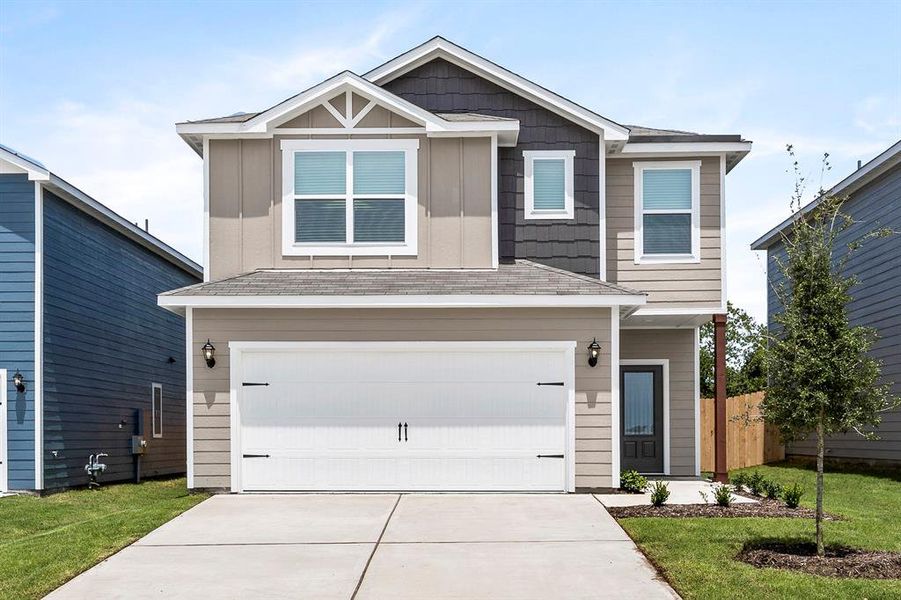 View of front facade with a garage and a front lawn