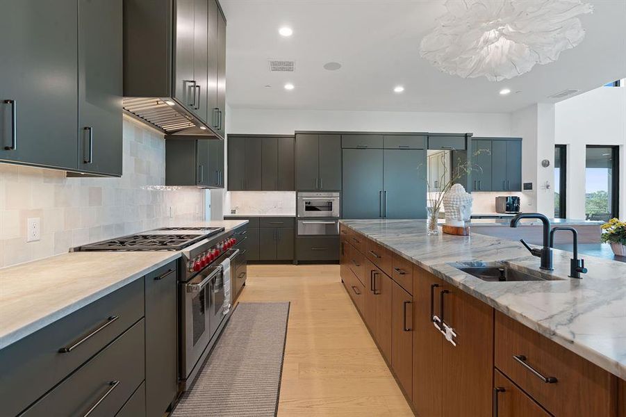 The true chef's kitchen comes stocked with custom cabinetry galore with high-end built-in appliances, and a bonus island sink.