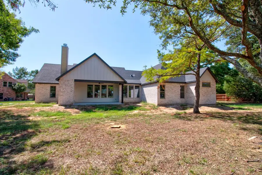 Rear view of property featuring a lawn and a patio area