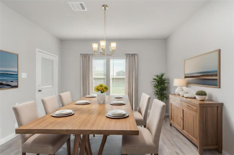 The elegant dining room is a perfect blend of sophistication and simplicity. With ample space to host gatherings, the room features a chic chandelier, a neutral color palette, and large windows that bring in abundant natural light. This inviting space is ideal for both casual family meals and formal dinner parties, providing a warm and welcoming environment for all occasions. **This image is from another Saratoga Home with similar floor plan and finishes, not the June floorplan.**