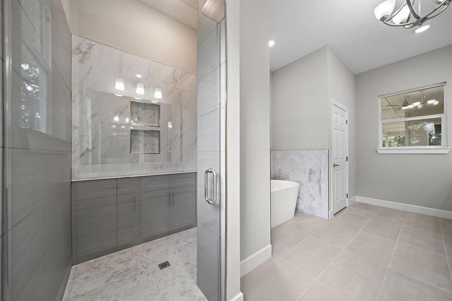 Primary Bath Shower with marble and porcelain tile. Shower handle within reach from door so no one gets sprayed with cold water!