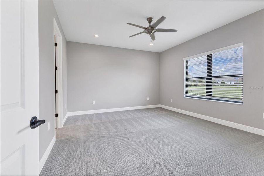 Primary bedroom with ceiling fan.