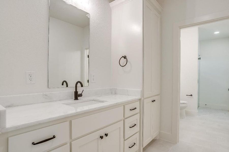 Bathroom with vanity, toilet, and tile patterned flooring