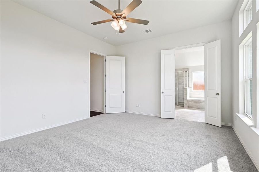 Unfurnished bedroom with ceiling fan and carpet floors