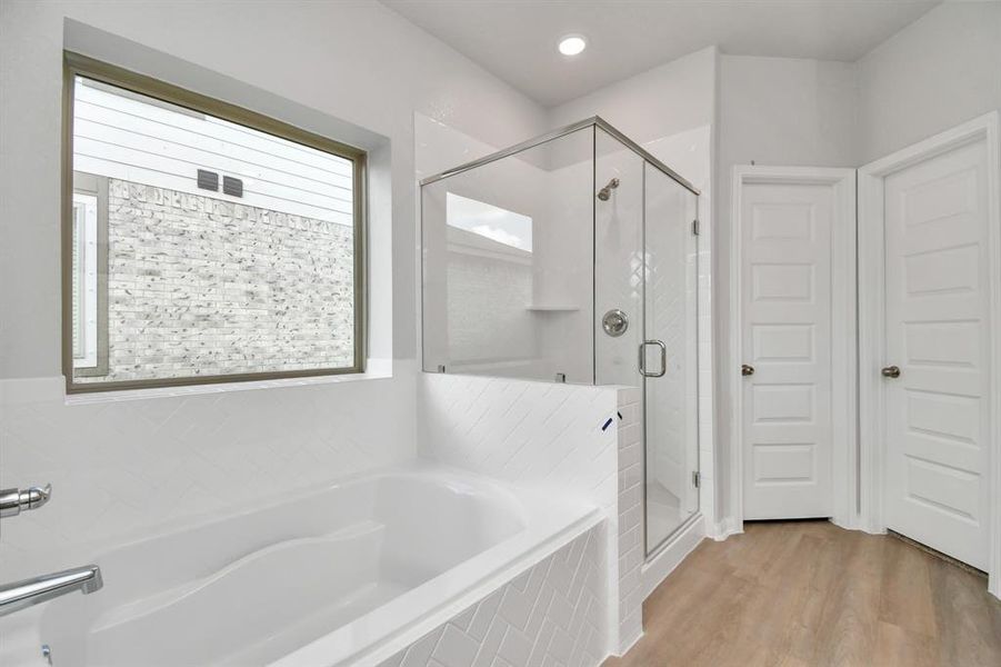 Discover another perspective of this beautiful primary bathroom full of natural light!