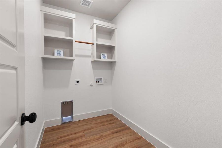 Clothes washing area with washer hookup, hardwood / wood-style flooring, hookup for a gas dryer, and electric dryer hookup