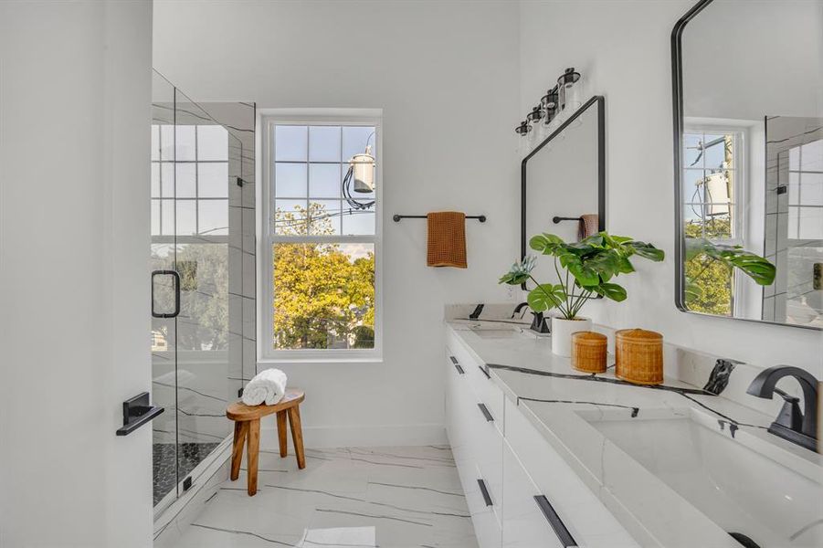 Bathroom featuring vanity, an enclosed shower, and a healthy amount of sunlight