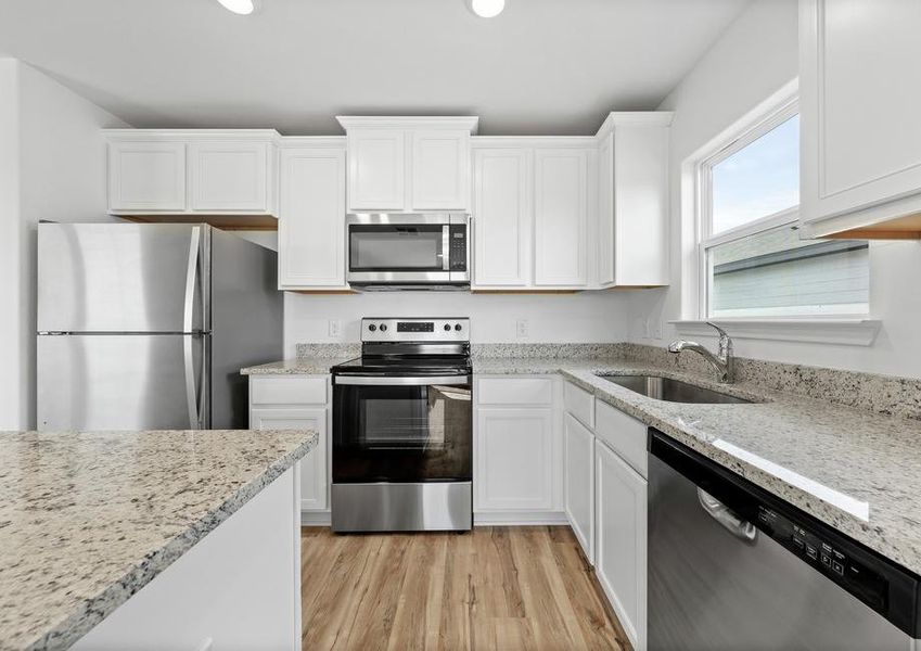 A kitchen with white cabinets and lots of counterspace