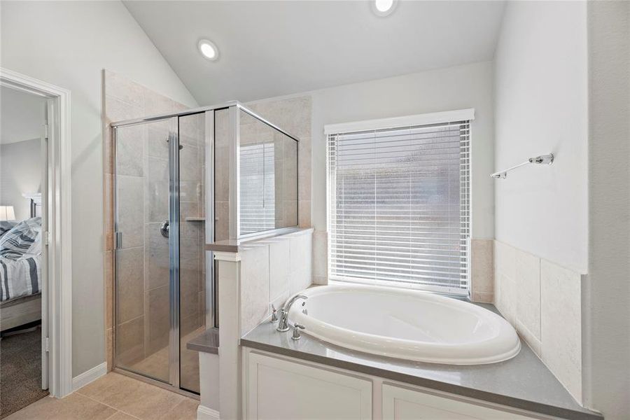 A relaxing primary bathroom that includes separate mud set shower and soaking tub