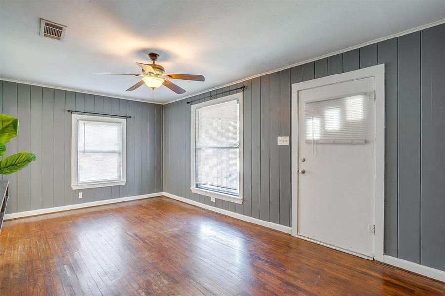 Entrance foyer with crown molding, wood walls, hardwood / wood-style flooring, and ceiling fan