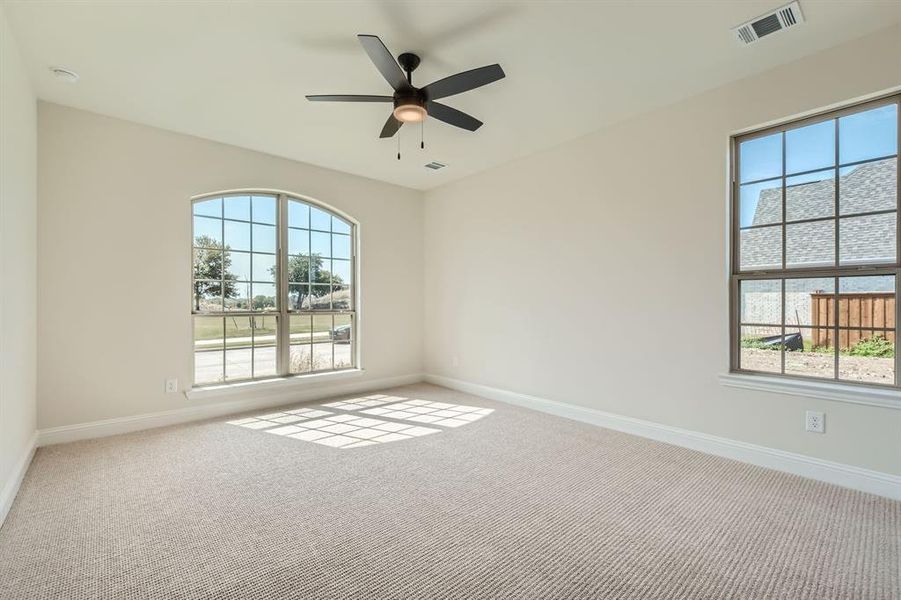 Carpeted empty room featuring ceiling fan