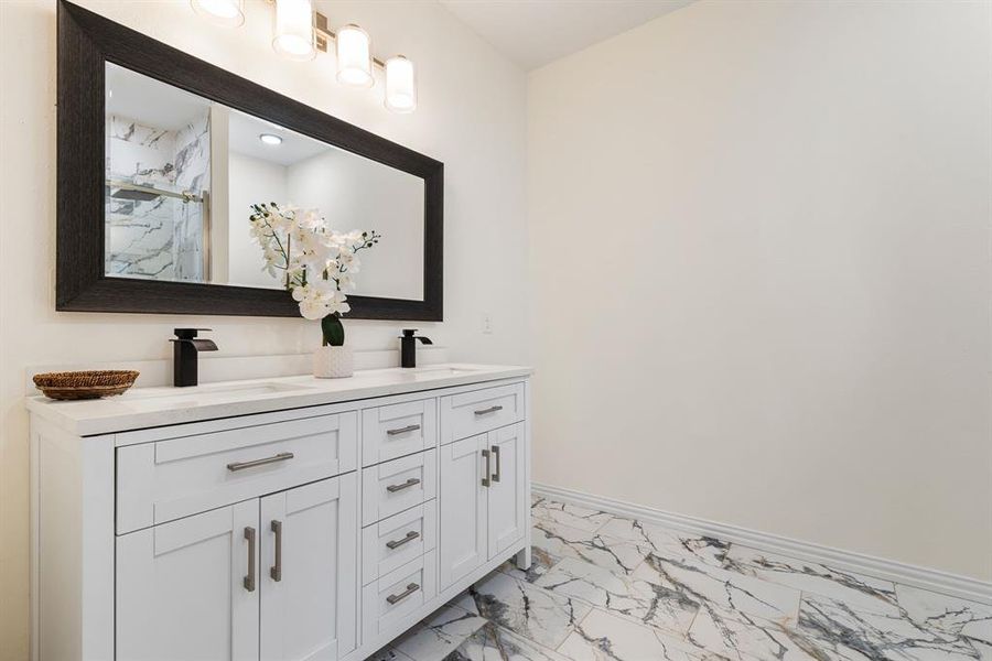 Bathroom with dual vanity and tile patterned floors