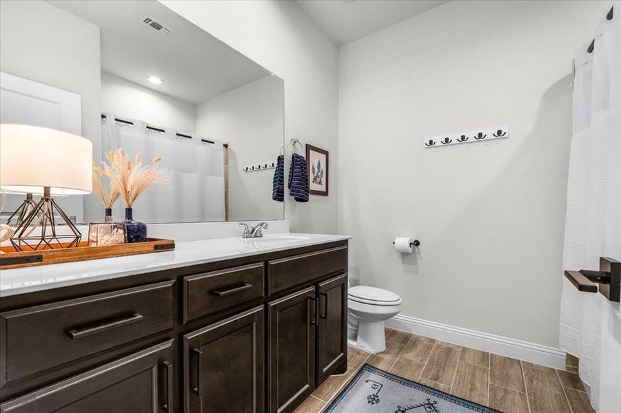 Bathroom with hardwood / wood-style floors, vanity, and toilet