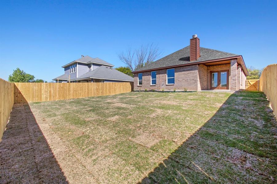 Rear view of property with a yard