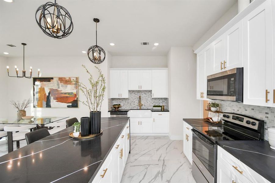 Chef's dream kitchen; upgraded waterfall island with Quartz counters, farmhouse sink with upgraded faucet, handles on the cabinetry, crown molding on the cabinets and luxurious pendant lights- this is your DREAM kitchen. All selections made by an interior designer.