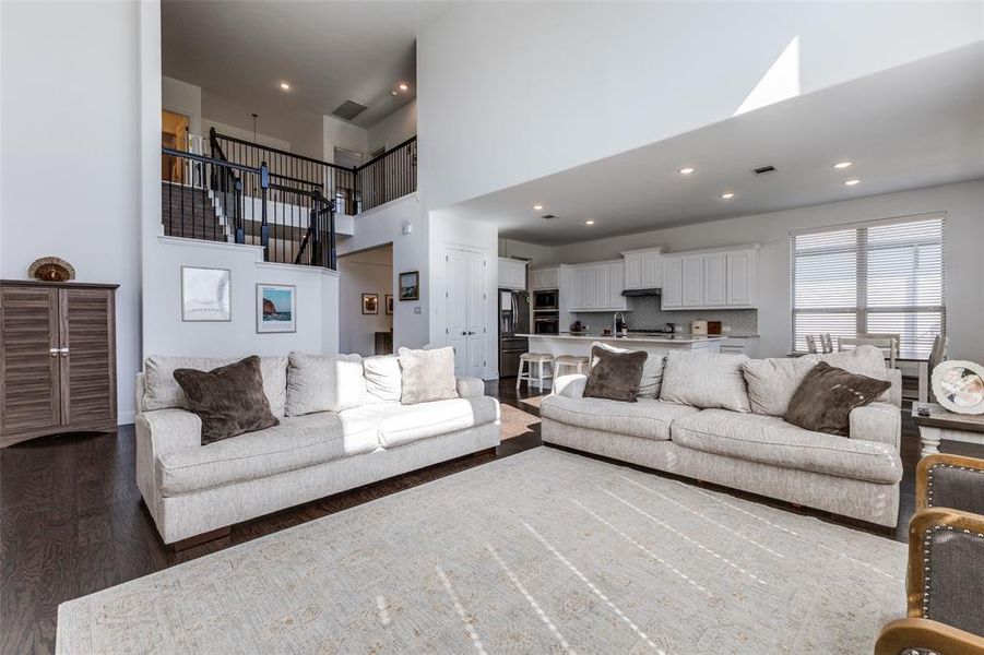 Living room with a towering ceiling and wood flooring