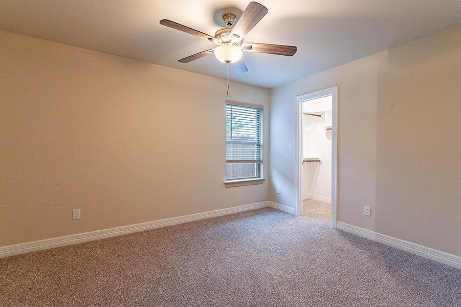 Carpeted empty room with ceiling fan