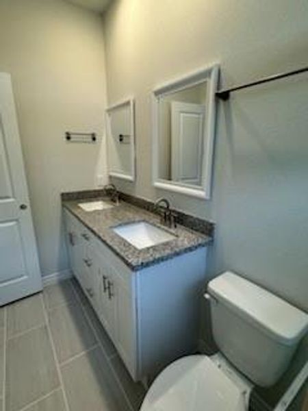 Primary en suite bath with double sinks, granite countertops