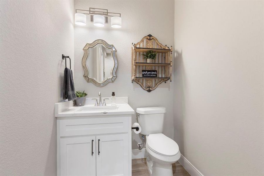 Half-bath is perfect for guests with modern fixtures and quartz countertops.