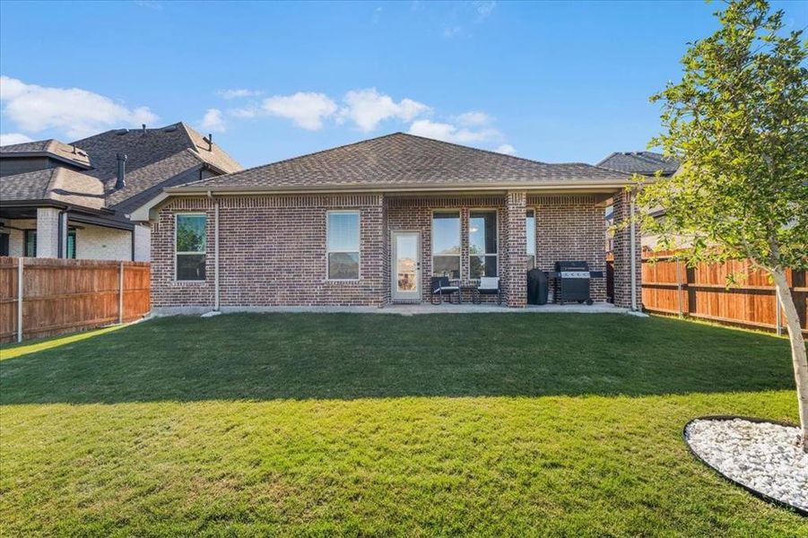 Rear view of house with a patio area and a yard