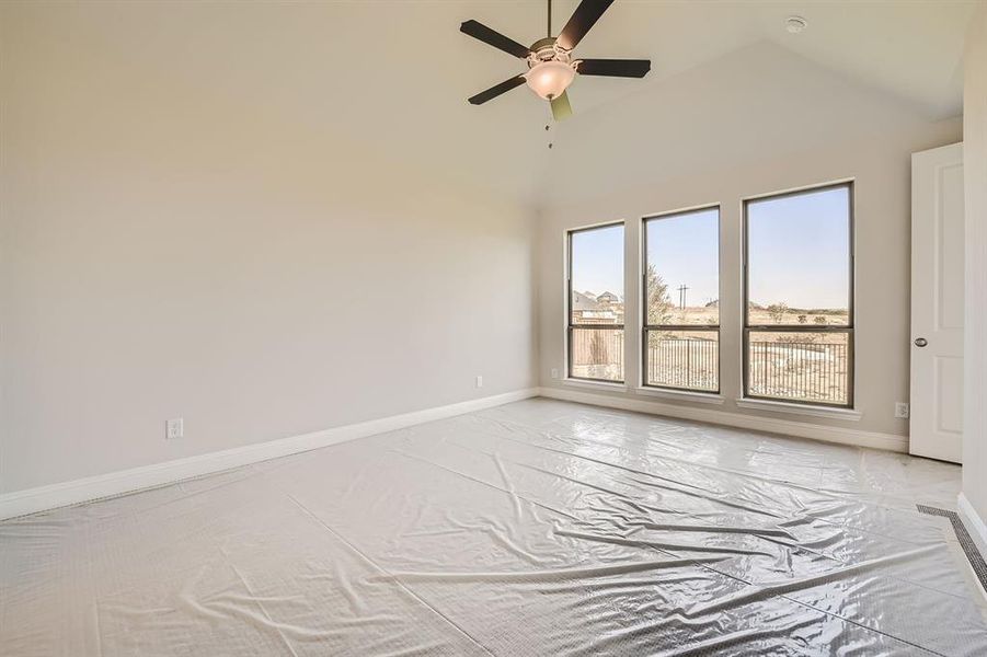 Unfurnished room with high vaulted ceiling and ceiling fan