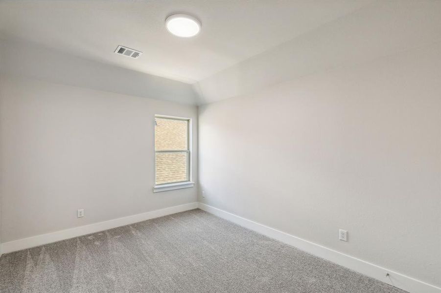 Carpeted empty room with vaulted ceiling