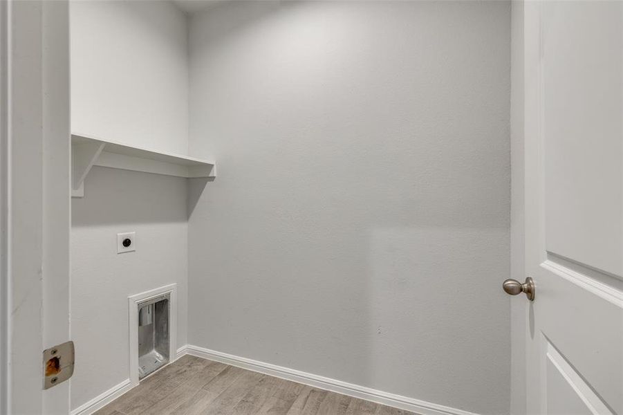 Laundry room featuring light hardwood / wood-style flooring and hookup for an electric dryer