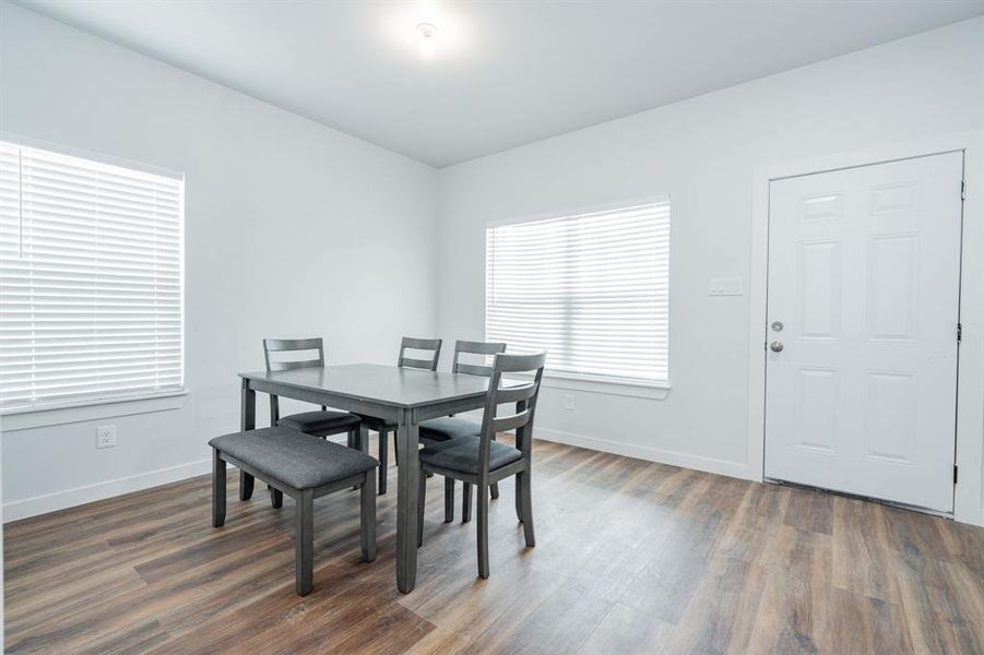 Dining space with dark hardwood / wood-style flooring