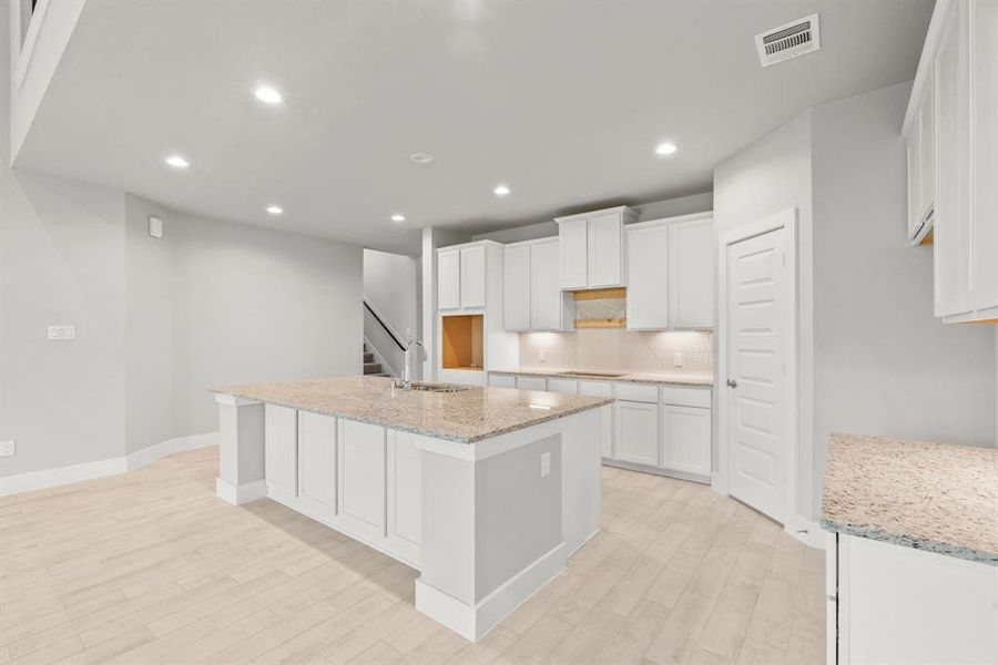 Discover another perspective of this stunning kitchen, generously appointed with an abundance of counter space. Sample photo of completed home with similar floor plan. Actual colors and selections may vary.