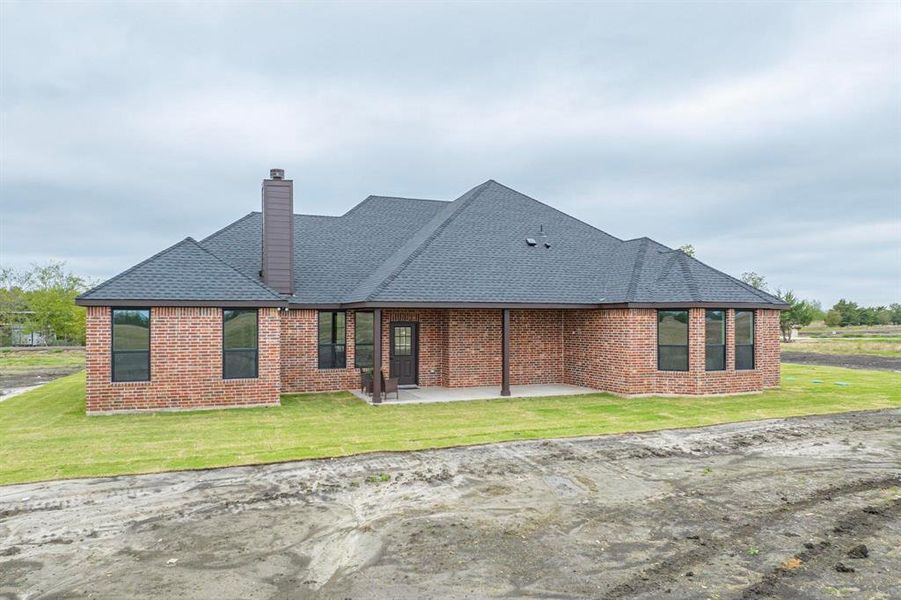 Rear view of house with a patio area and a yard