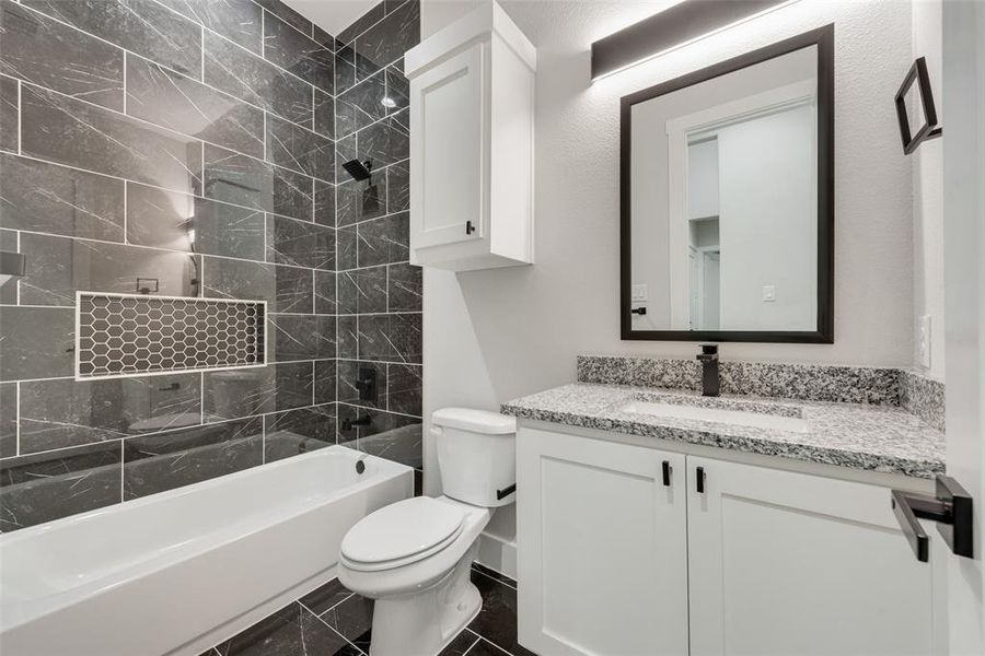 Full bathroom with vanity, toilet, and tiled shower / bath