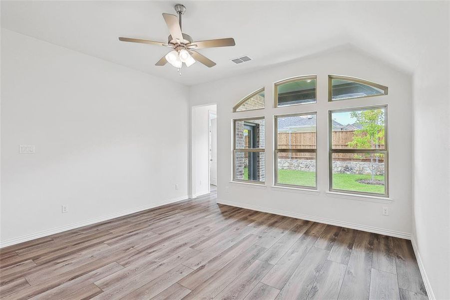 Unfurnished room featuring light hardwood / wood-style floors, ceiling fan, and vaulted ceiling