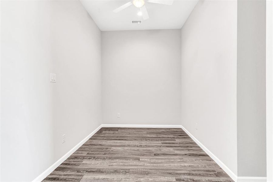 Flex room adjoining primary bedroom featuring wood-type flooring and ceiling fan