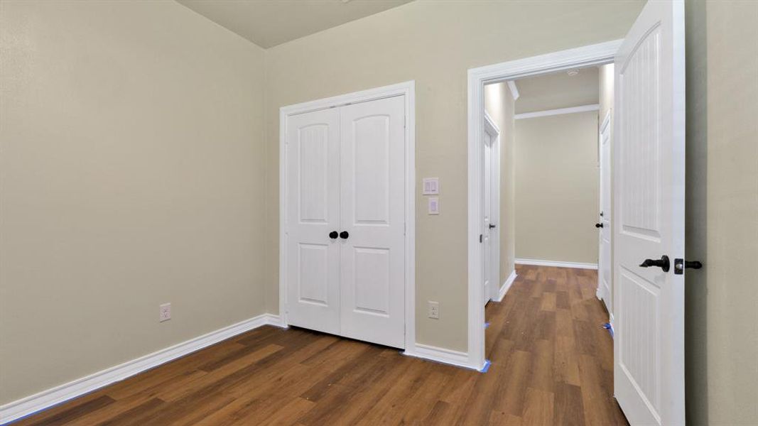 Unfurnished bedroom featuring dark hardwood / wood-style floors