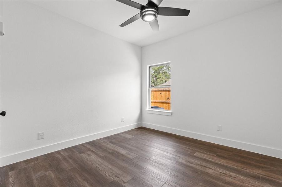 Spare room featuring dark hardwood / wood-style flooring and ceiling fan