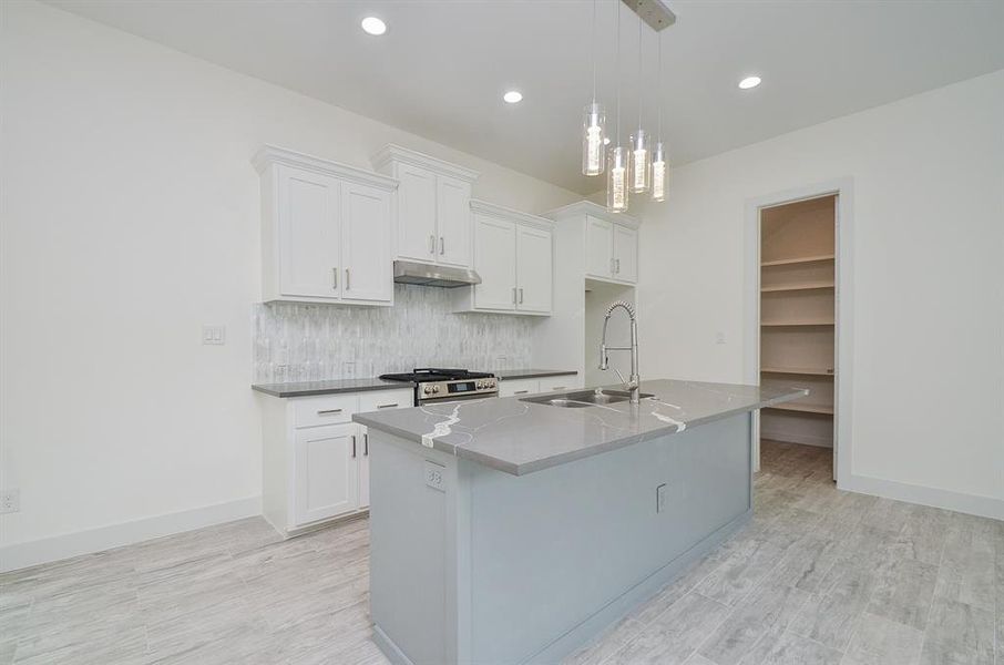 A chef's dream! Well-lit open Kitchen is perfect for entertaining featuring a large quartz island with breakfast bar seating, SS appliances & a large pantry.