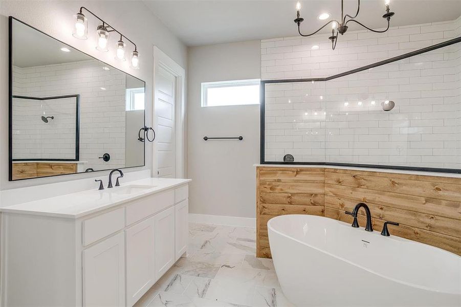 Bathroom with an inviting chandelier, a bath, tile floors, and large vanity