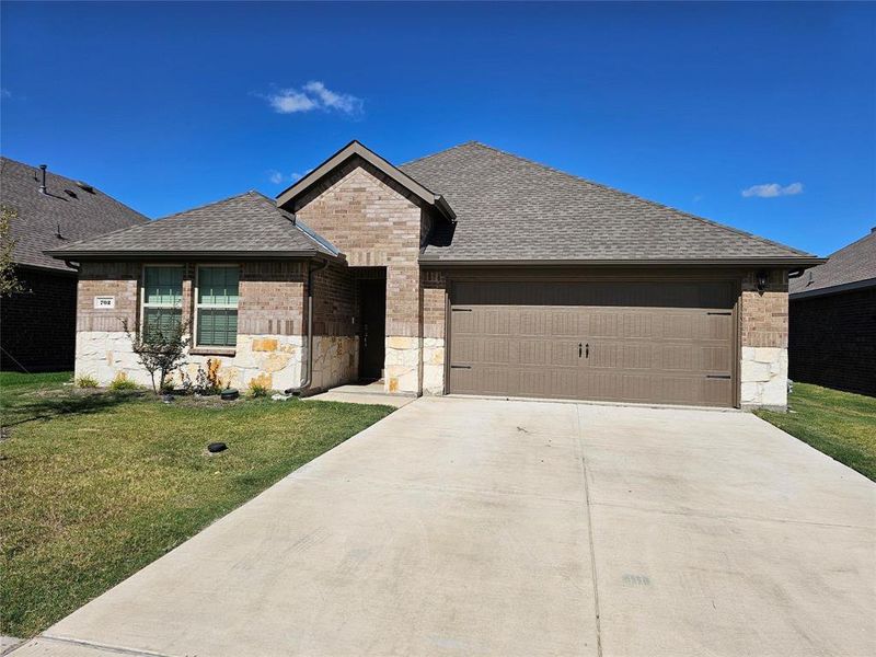 View of front of home with a front yard and a garage