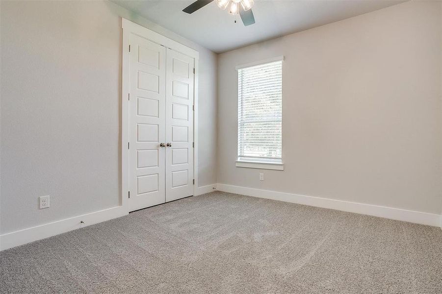 Unfurnished bedroom featuring a closet, carpet floors, and ceiling fan