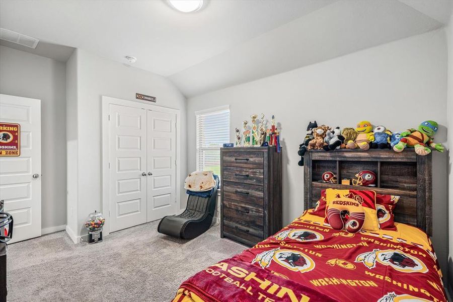 Bedroom with vaulted ceiling, carpet, and a closet