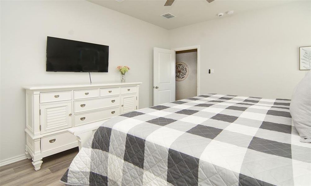 Bedroom with ceiling fan and light hardwood / wood-style flooring