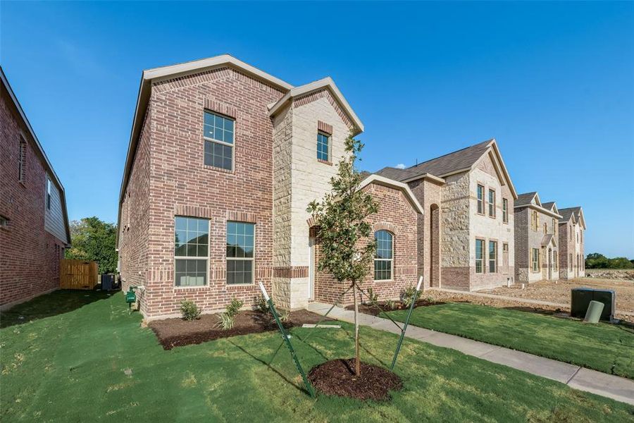 View of front of house with central AC and a front yard