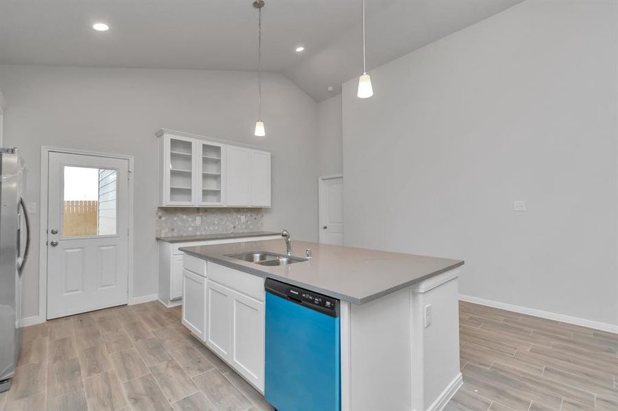 The modern kitchen is a chef's dream, featuring stainless steel appliances, ample countertop space, and crisp white cabinetry. The central island offers additional prep space and casual dining options, making this kitchen both functional and stylish. **This image is from another Saratoga Home - Wren floorplan.**