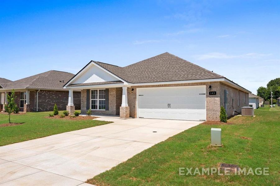 View of front of home with a garage, a front yard, and central AC unit