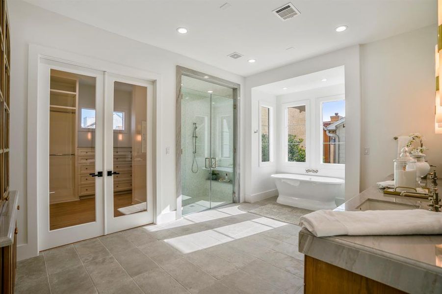 Breathtaking primary bathroom with incredible high-end features. There are two walk-in closets inside this primary bathroom, separate soaking tub, stand-up shower, and a custom built linen closet.