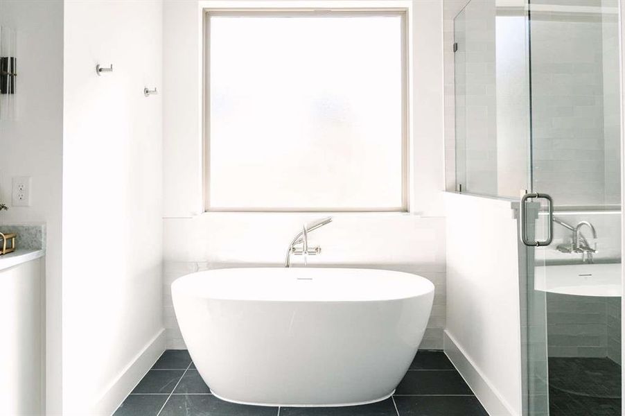 Bathroom featuring tile patterned flooring and shower with separate bathtub