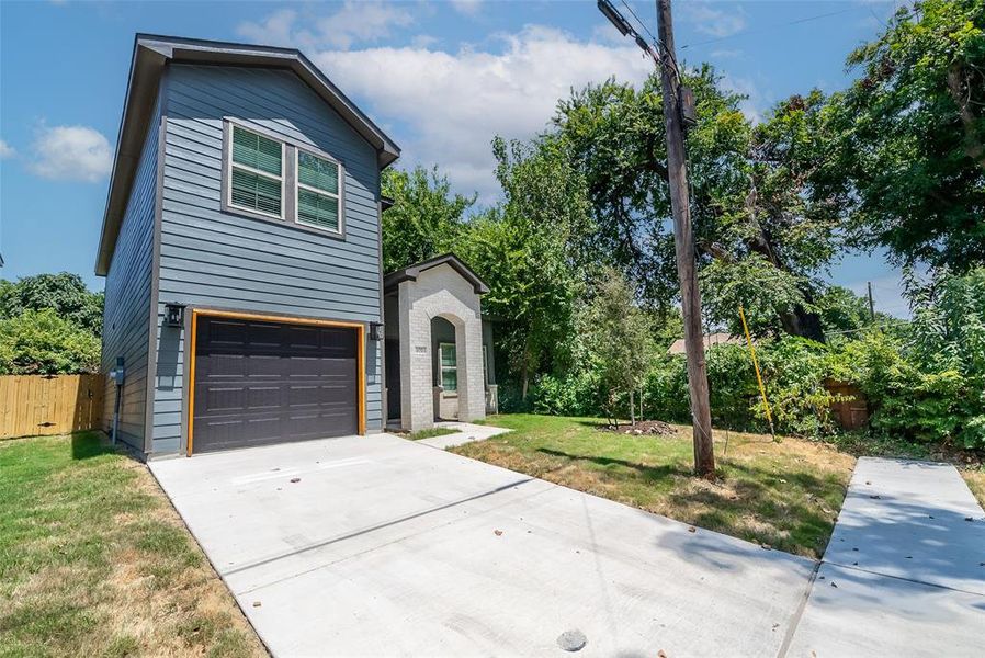 View of front of home with a front lawn and a garage