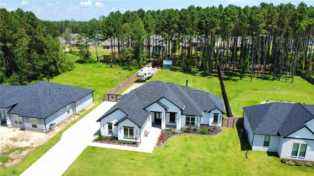 EXPERIENCE THE SERENITY OF SUBURBAN LIVING WITH THIS BEAUTIFULLY DESIGNED HOME FEATURING AN EXPANSIVE YARD BORDERED BY LUSH PINE WOODS, PERFECT FOR THOSE WHO VALUE BOTH STYLE AND SECLUSION.