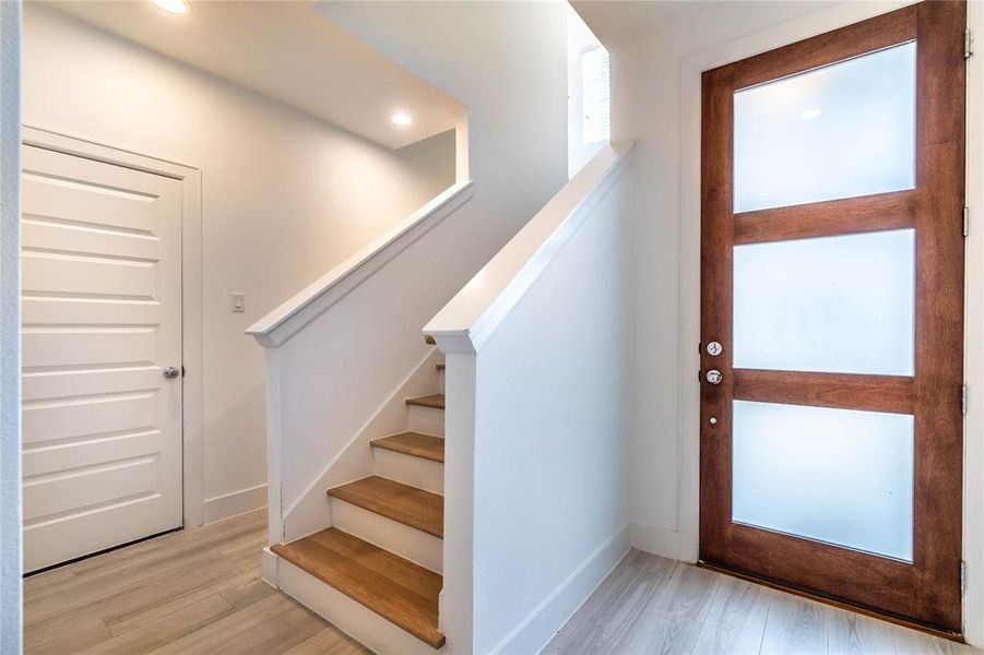 Entrance showing the front door, stairs to the second floor and the access to the garage.