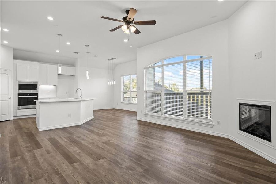 Unfurnished living room with ceiling fan, sink, and dark hardwood / wood-style flooring